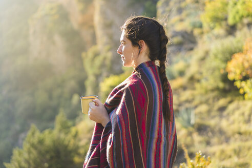 Spain, Alquezar, young woman with coffee mug in nature - AFVF01311