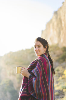 Spanien, Alquezar, Porträt einer lächelnden jungen Frau mit Kaffeetasse in der Natur - AFVF01312