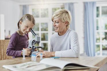 Mutter und Tochter benutzen das Mikroskop zu Hause - RORF01386