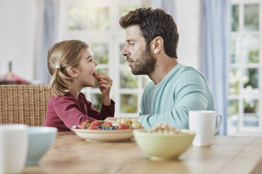 Vater und Tochter essen Obst zu Hause - RORF01390