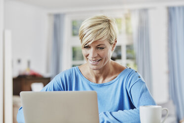 Woman using laptop at home - RORF01391