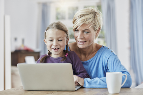 Mutter und Tochter benutzen Laptop zu Hause, lizenzfreies Stockfoto