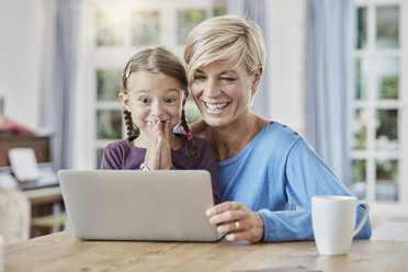 Mother and surprised daughter using laptop at home - RORF01393