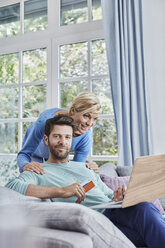 Portrait of couple at home shopping online - RORF01401