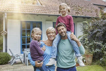 Porträt einer glücklichen Familie mit zwei Kindern vor ihrem Haus - RORF01426