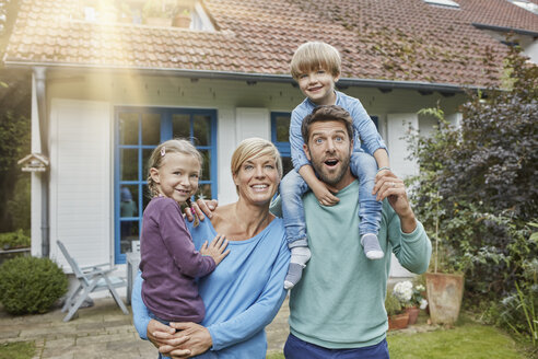 Porträt einer glücklichen Familie mit zwei Kindern vor ihrem Haus - RORF01428