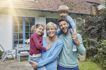 Porträt einer glücklichen Familie mit zwei Kindern vor ihrem Haus - RORF01429