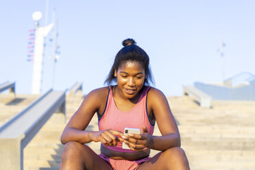 Junge sportliche Frau mit Smartphone - AFVF01321