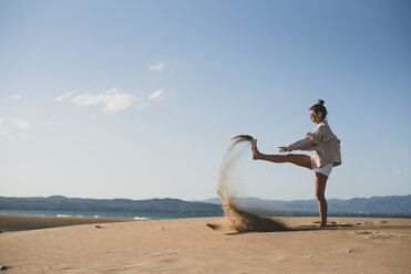 Teenager-Mädchen wirft Sand am Strand - ACPF00166