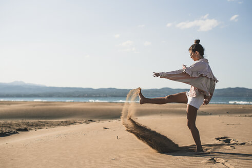 Teenage girl throwing sand on the beach - ACPF00168