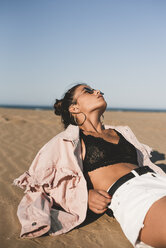 Fashionable teenage girl lying on the beach - ACPF00170