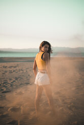 Portrait of teenage girl standing on the beach at sunset - ACPF00182