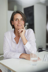 Portrait of pensive mature businesswoman sitting at desk - PNEF00845