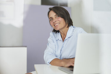 Porträt einer lächelnden reifen Geschäftsfrau in einem Büro - PNEF00848