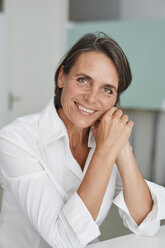 Portrait of smiling mature businesswoman wearing white blouse - PNEF00855