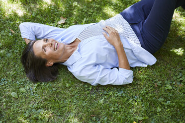 Portrait of mature woman relaxing on a meadow - PNEF00856