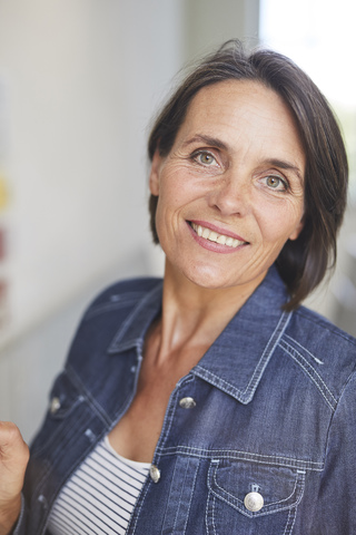 Porträt einer lächelnden reifen Frau mit Jeanshemd, lizenzfreies Stockfoto