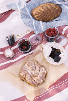 Hochformatige Ansicht von Essen auf einer Picknickdecke, Brot und Obst. - MINF06036