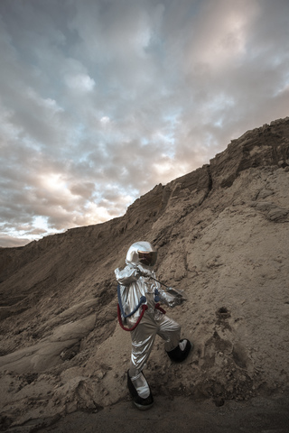 Spaceman on nameless planet taking samples of sand stock photo