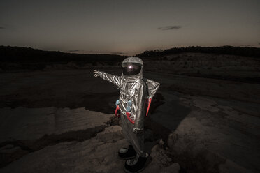 Raumfahrer, der in der Nacht auf einem namenlosen Planeten in die Ferne zeigt - VPIF00503