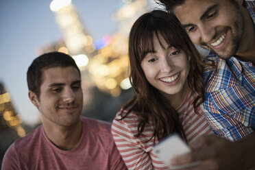 A small group of friends gathered on a rooftop terrace overlooking a city at twilight. - MINF06062