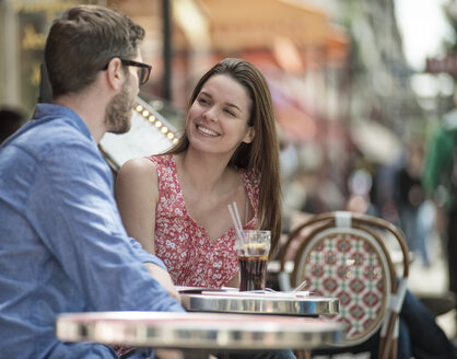 Ein Paar sitzt in einem Straßencafé in einer Stadt. - MINF06080