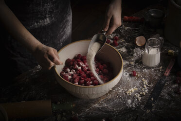 Backen zum Valentinstag, Frau bereitet frische Himbeeren in einer Schüssel vor und fügt Zucker hinzu. - MINF06155