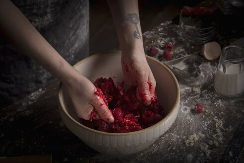 Valentine's Day baking, woman preparing fresh raspberries in a bowl. - MINF06158