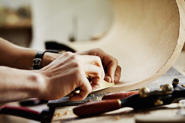 Eine Möbelwerkstatt, die zeitgenössische Möbelstücke nach Maß herstellt und dabei traditionelle Fertigkeiten mit modernem Design verbindet. Ein Mann arbeitet an einem Stück gebogenen Holzes. - MINF06215