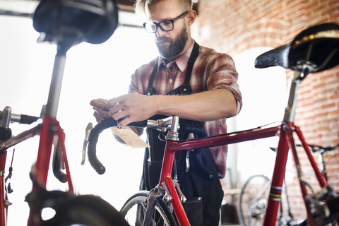 Ein Mann arbeitet in einer Fahrradwerkstatt., lizenzfreies Stockfoto