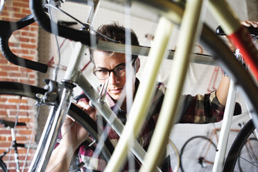 Ein Mann arbeitet in einer Fahrradwerkstatt. - MINF06284