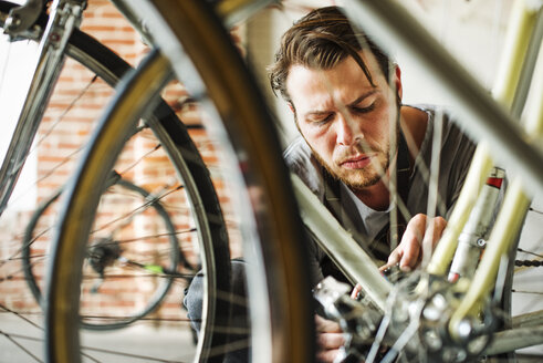 Ein Mann arbeitet in einer Fahrradwerkstatt. - MINF06302