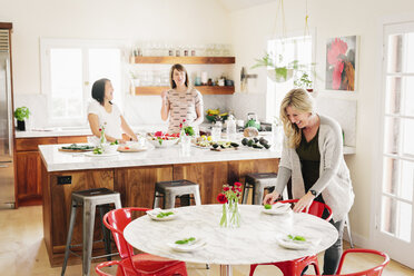 Drei Frauen in einer Küche bereiten das Mittagessen vor. - MINF06339