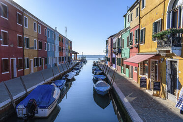 Kleine Motorboote, die in engen Kanälen mit bunten Häusern festgemacht sind, Venedig, Italien. - MINF06493