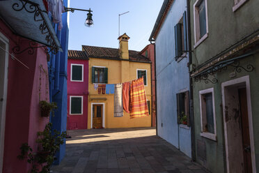 Narrow alley with colourful facades and clothes on washing line in Venice, Italy. - MINF06494