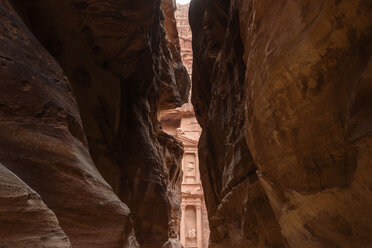 View through narrow rock formation towards rock-cut architecture of Al Khazneh or The Treasury at Petra, Jordan. - MINF06497