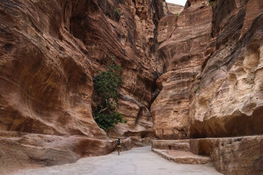 Man walking along path through rock formations at Petra, Jordan. - MINF06499