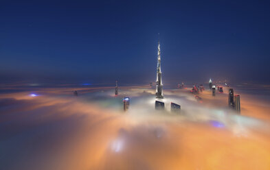 Blick auf den beleuchteten Burj Khalifa und andere Wolkenkratzer über den Wolken in Dubai, Vereinigte Arabische Emirate. - MINF06522