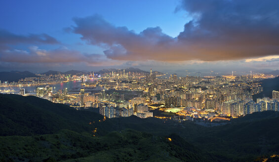 Blick über Kowloon mit der Stadt Hongkong mit beleuchteten Wolkenkratzern in der Abenddämmerung. - MINF06527