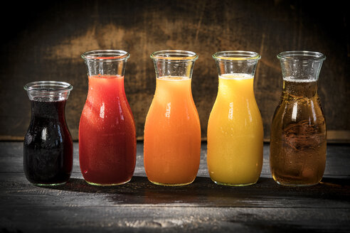 Reihe von fünf Glasflaschen mit verschiedenen Fruchtsäften - MAEF12683