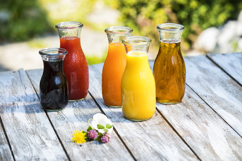 Glass bottles of various fruit juices stock photo