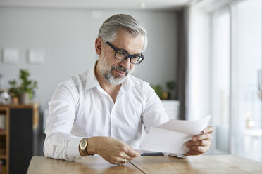 Portrait of mature man reading letter at home - RBF06472