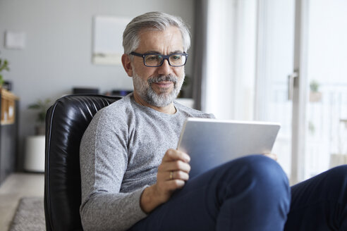 Porträt eines reifen Mannes, der zu Hause ein Tablet benutzt - RBF06476