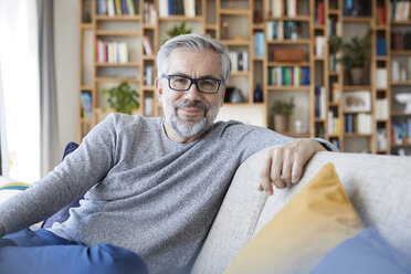 Portrait of smiling mature man relaxing on couch at home - RBF06484