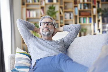 Porträt eines Erwachsenen, der sich zu Hause auf der Couch entspannt - RBF06492