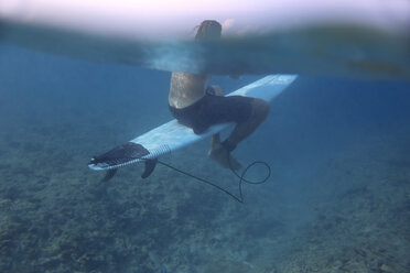 Maledives, Indian Ocean, surfer sitting on surfboard, underwater shot - KNTF01187