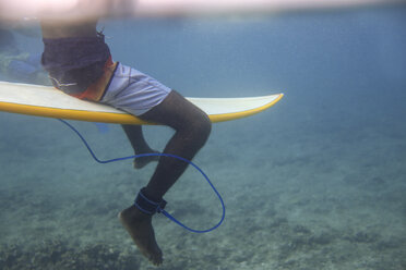 Malediven, Indischer Ozean, Surfer auf Surfbrett sitzend, Unterwasseraufnahme - KNTF01188