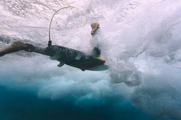 Maledives, Indian Ocean, surfer on surfboard, underwater shot - KNTF01205