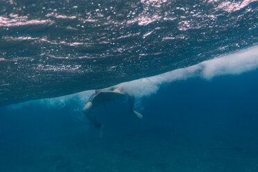 Maledives, Indian Ocean, surfer sitting on surfboard, underwater shot - KNTF01206