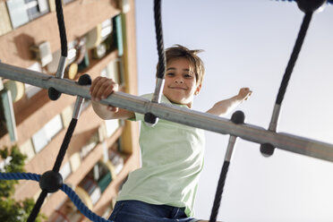 Porträt eines kleinen Mädchens auf einem Klettergerüst - JSMF00397
